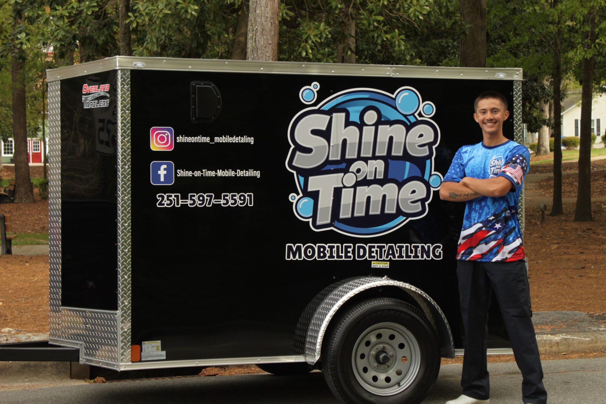 This shows the owner in front of his mobile detailing trailer..